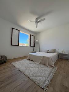 een witte slaapkamer met een bed en een raam bij Grande maison familiale Leucate Village in Leucate