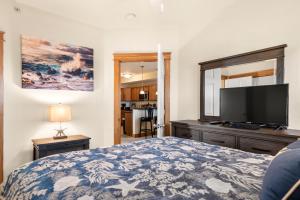 a bedroom with a bed and a flat screen tv at Knot Of Sound Mind in Nags Head
