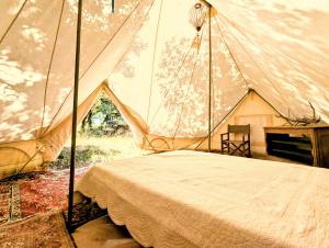 una camera da letto con un letto in una tenda di Glamping Grignan 3 personnes vue exceptionnelle a Réauville