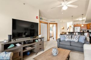 a living room with a couch and a flat screen tv at Knot Of Sound Mind in Nags Head