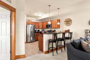 a kitchen with a refrigerator and a counter with stools at Knot Of Sound Mind in Nags Head +11 photos