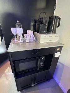 un mostrador con copas de vino y otros artículos. en LoveroomL1TIMISTE TAR, en La Rochelle