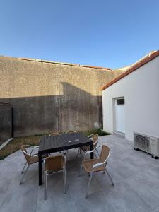 ein schwarzer Tisch und Stühle auf einer Terrasse in der Unterkunft Maison La Pornicaise 11 in Saint-Jean-de-Monts