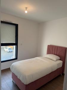 ein Schlafzimmer mit einem großen Bett mit Fenster in der Unterkunft Maison La Pornicaise 11 in Saint-Jean-de-Monts