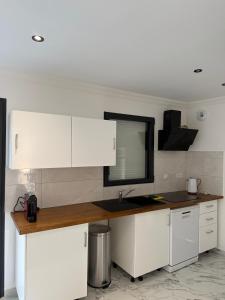 eine Küche mit weißen Schränken und einer Spüle in der Unterkunft Maison La Pornicaise 11 in Saint-Jean-de-Monts