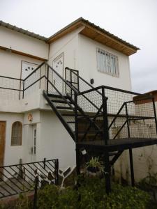 a black spiral staircase in front of a house at Hostel La Casa de Tounens in Puerto Madryn