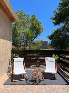 twee stoelen en een tafel op een patio bij Grande maison familiale Leucate Village in Leucate