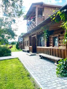 a log cabin with a bench in front of it at «У полоні гір» in Verkhovyna