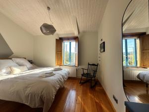 Un dormitorio con una cama grande y un espejo. en Casa do Bidueiro, en Luou