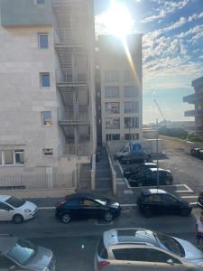 a parking lot with cars parked in front of a building at ALMIA casa vacanze in Fiumicino