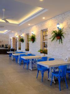 a row of tables and blue chairs in a restaurant at KUPALA BEACH HOTEL in Büyükkeçeli