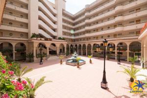 an empty courtyard of a large building with a fountain at Cordoba IBERPLAYA in Salou