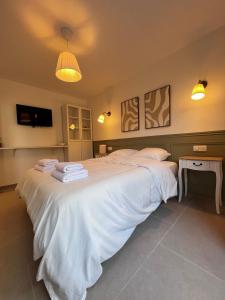 a bedroom with a large white bed with towels on it at Studio Avignon MONTFAVET in Avignon