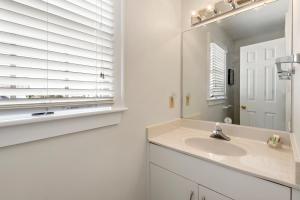 a white bathroom with a sink and a mirror at Lauren Lee in Nags Head