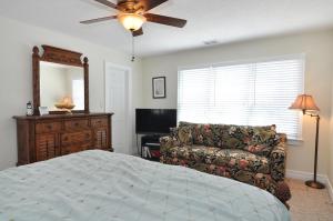 a bedroom with a bed and a couch and a ceiling fan at Lauren Lee in Nags Head