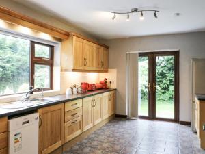 a kitchen with wooden cabinets and a sink at Lilly's Bungalow in Timoleague