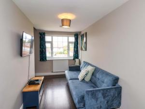 Una sala de estar con un sofá azul y una mesa. en Hazelgarth House, en Filey