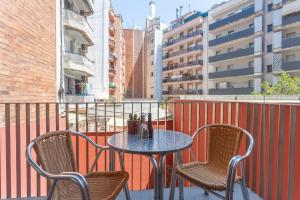 - une table et des chaises sur un balcon avec des bâtiments dans l'établissement Apartment Barcelona Rentals - Pool Terrace in City Center, à Barcelone