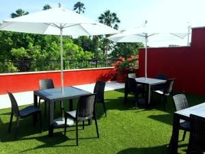 a patio with tables and chairs and an umbrella at Hotel San Pablo in Colima