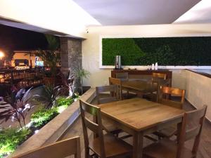 a restaurant with tables and chairs and a green wall at Hotel San Pablo in Colima