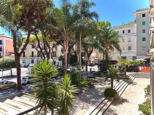 a park with palm trees and benches in a city at Cabot Cove in Gaeta