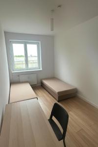 a room with two beds and a chair in it at Noclegi Gdynia Chrzanowskiego in Gdynia