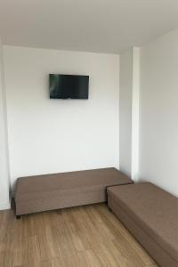 a room with two beds and a tv on a wall at Noclegi Gdynia Chrzanowskiego in Gdynia +6 photos