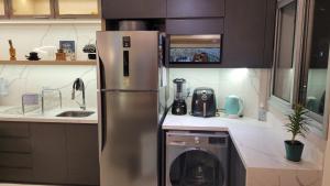 a kitchen with a stainless steel refrigerator and a dishwasher at Lindo apartamento centro de Floripa in Florianópolis