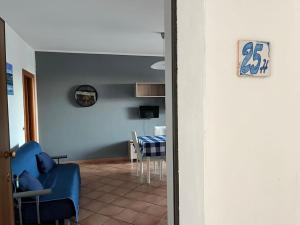 a living room with a table and a blue chair at Parco Meridiana 25H in Scalea