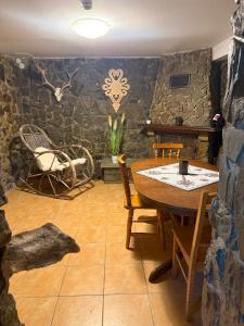 扎科帕内Kowali Wierch的餐厅里有一张桌子和一面石墙。
