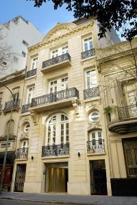a large white building with balconies on a street at Poetry Building Recoleta in Buenos Aires