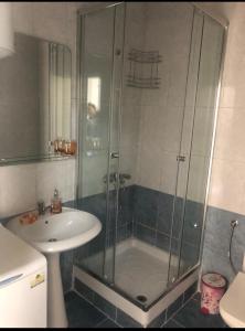 a bathroom with a glass shower and a sink at Apartment Una in Becici