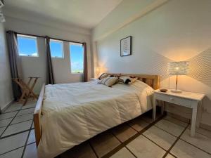 a bedroom with a bed and a table and windows at Vista al Mar Residencias Laguna Blanca in Tucacas +23 photos