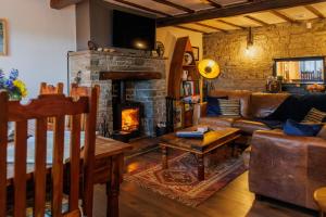 a living room with a couch and a fireplace at Wells Cottage in Holmfirth