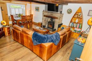 a living room with a large couch and a fireplace at Wells Cottage in Holmfirth