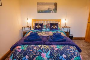 a bedroom with a large bed with blue pillows at Wells Cottage in Holmfirth