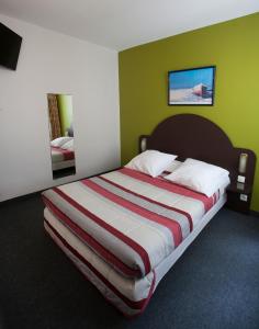 a large bed in a room with green walls at Bistrot Les Sans Culottes in Paris