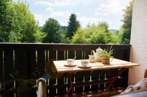 a table on a balcony with a view of trees at Gemütliche Ferienwohnung mit Blick ins Grüne in Zwiesel