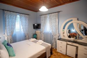 a bedroom with a bed and a mirror and curtains at Μικρός Παράδεισος - Αγροτουριστική Κατοικία  +11 photos