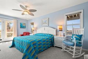 a blue bedroom with a bed and a chair at No Regrets in Nags Head +23 photos