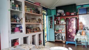 a dining room with a table and some shelves at Sunyog Homestay in Pedong