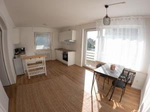 a living room with a table and a kitchen with a window at Moderne Zimmer in zentraler Lage bei Stay Time in Steinhagen