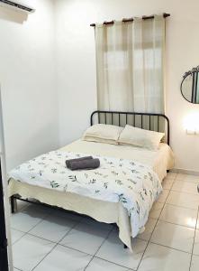 a bedroom with a bed with a black frame at Homestay Dataran Tikam Batu in Sungai Petani