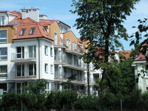 un grand bâtiment blanc avec un toit rouge dans l'établissement Apartament Waterside, à Giżycko