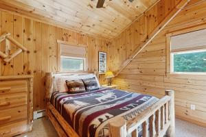 ein Schlafzimmer mit einem Bett in einer Blockhütte in der Unterkunft The Den In Franconia in Franconia