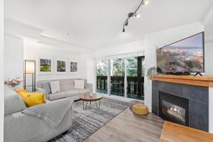 a living room with a couch and a fireplace at Amazing Village Location with PRIVATE Hot Tub in Whistler