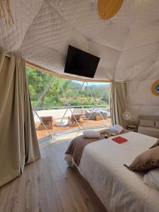a bedroom with a bed with a flat screen tv on the ceiling at Domo AWA Magia y Naturaleza in Ucenda