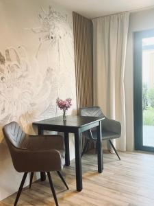 a dining room with a table and two chairs at Pokoje Gościnne Lidka in Dziwnów