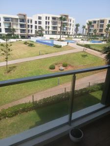 a view of a park from a balcony of a building at Prestigia plage des Nations in Sale