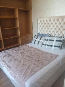a bedroom with a large bed with a headboard at Prestigia plage des Nations in Sale